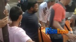 Petugas kepolisian bersama warga mengevakuasi jasad pria yang ditemukan mengapung di Sungai Siak dekat penyeberangan feri Perawang, Kecamatan Tualang.