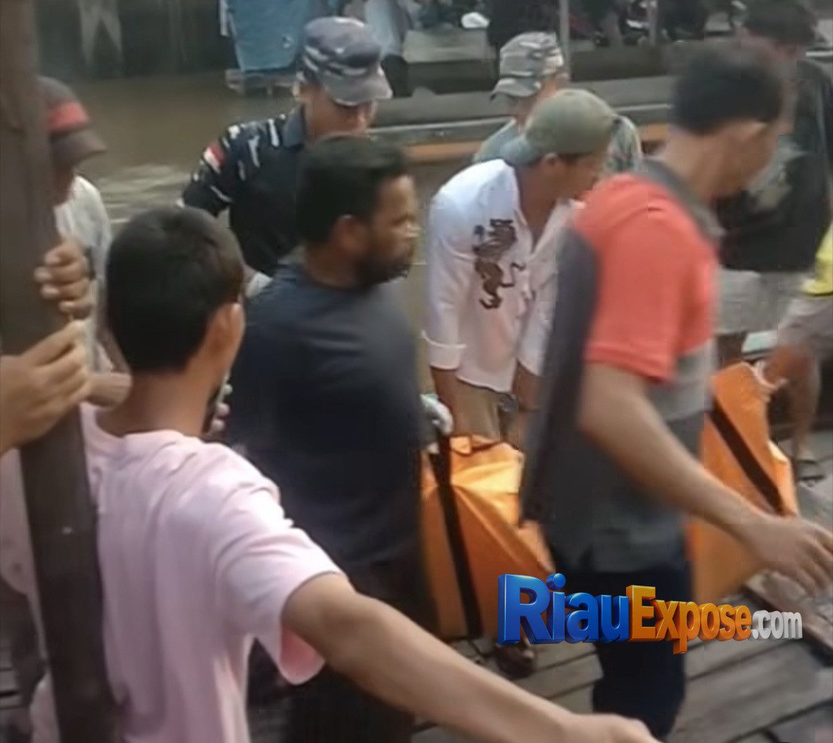 Petugas kepolisian bersama warga mengevakuasi jasad pria yang ditemukan mengapung di Sungai Siak dekat penyeberangan feri Perawang, Kecamatan Tualang.