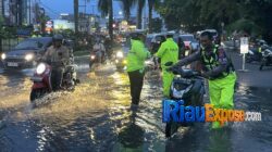 Dirlantas Polda Riau Kombes Jeki Rahmat Mustika memimpin langsung pengaturan lalu lintas saat Jalan Jenderal Sudirman depan RS Awal Bros Pekanbaru tergenang akibat hujan deras.