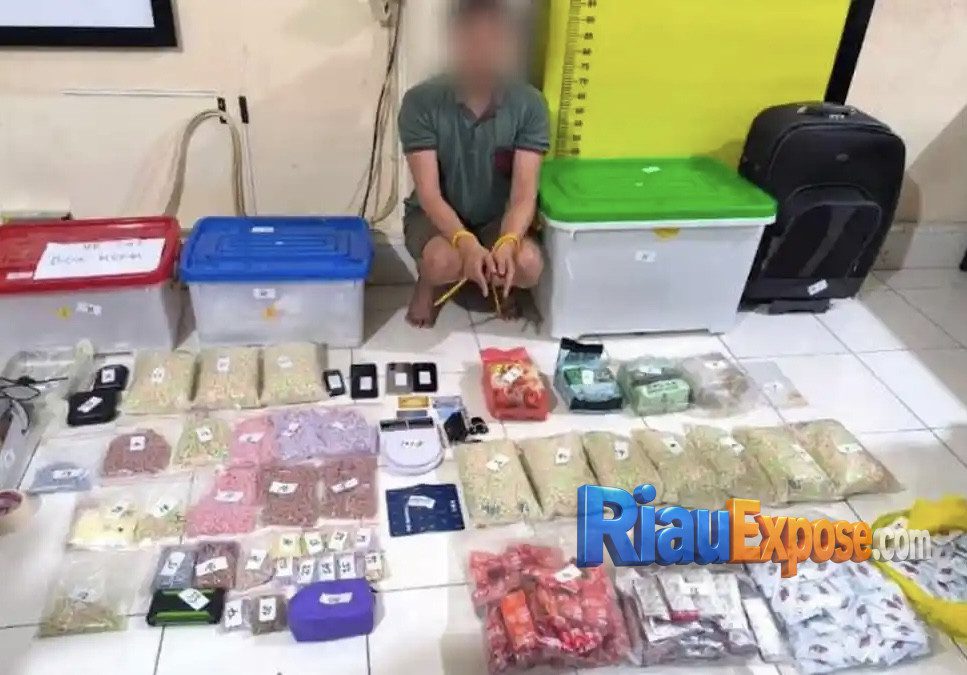 Petugas Direktorat Reserse Narkoba Polda Riau menunjukkan barang bukti 4 kilogram sabu, puluhan ribu pil ekstasi, dan tersangka kasus gudang narkoba di Pekanbaru.