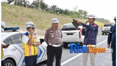 Pengendara melintasi Jalan Tol Pekanbaru-Dumai dengan informasi pengalihan akses keluar menuju Pintu Tol Bypass Pekanbaru.